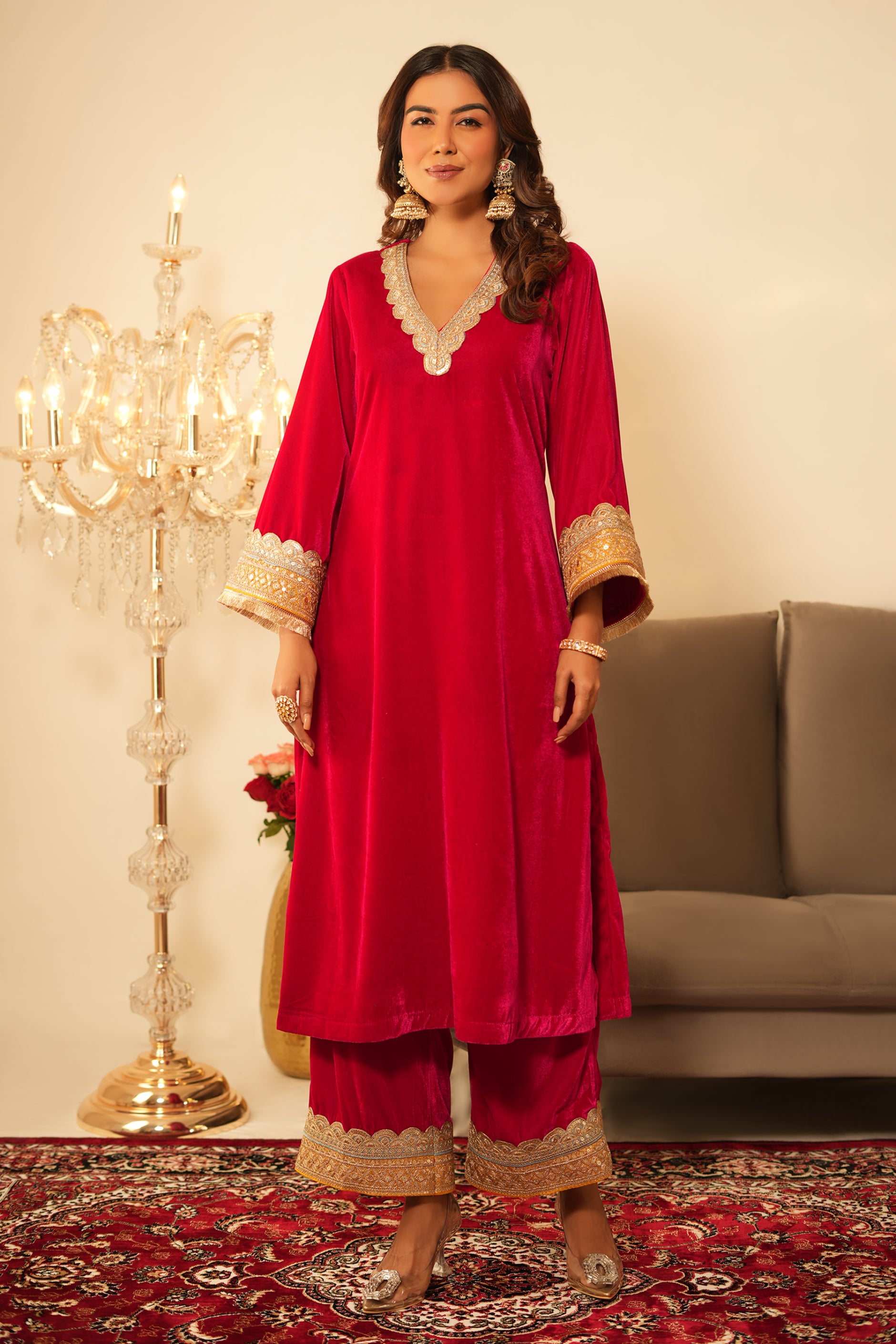 Woman wearing Pink Velvet Kurta with Pants Set of 2 featuring intricate contrast lace detailing on neckline, sleeves and pant hem, V neckline, full sleeves, and matching pink velvet pants
