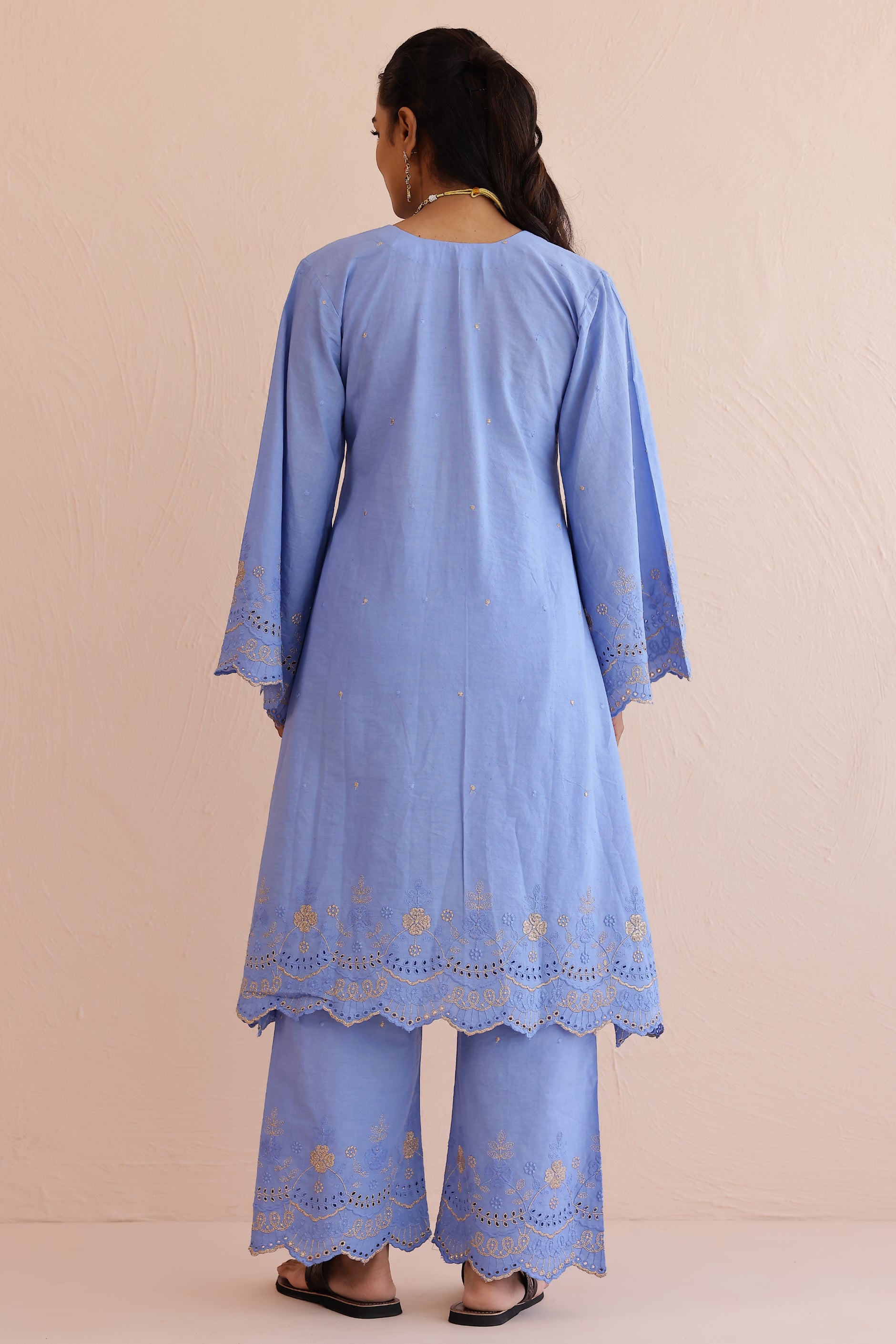 Woman wearing blue embroidered cotton A-line kurta with full sleeves and matching embroidered pants.