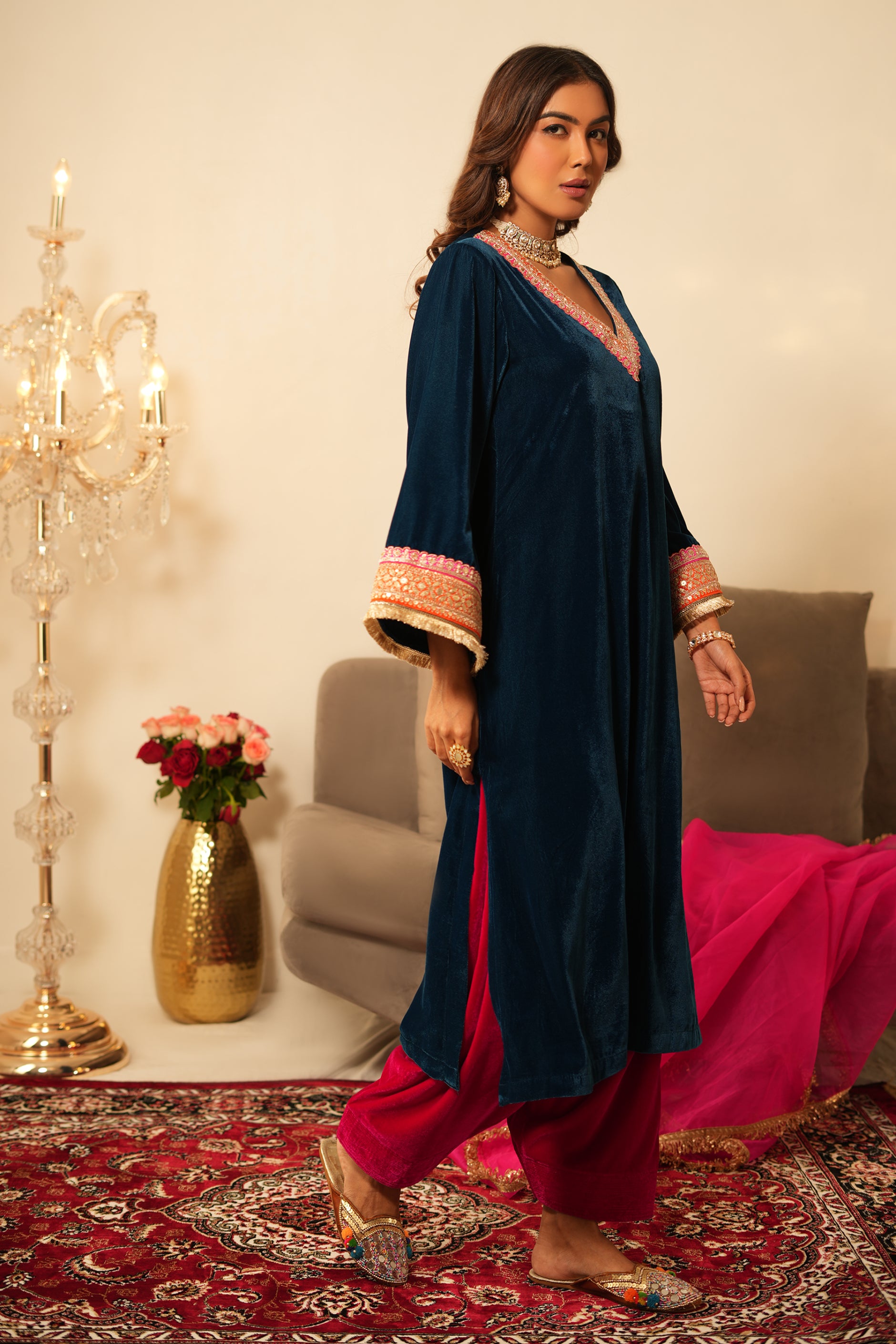Woman wearing Blue Velvet Kurta with Pink Velvet Salwar Set of 2 featuring gota lace detailing, notched round neckline, full sleeves, and matching pink velvet salwar 