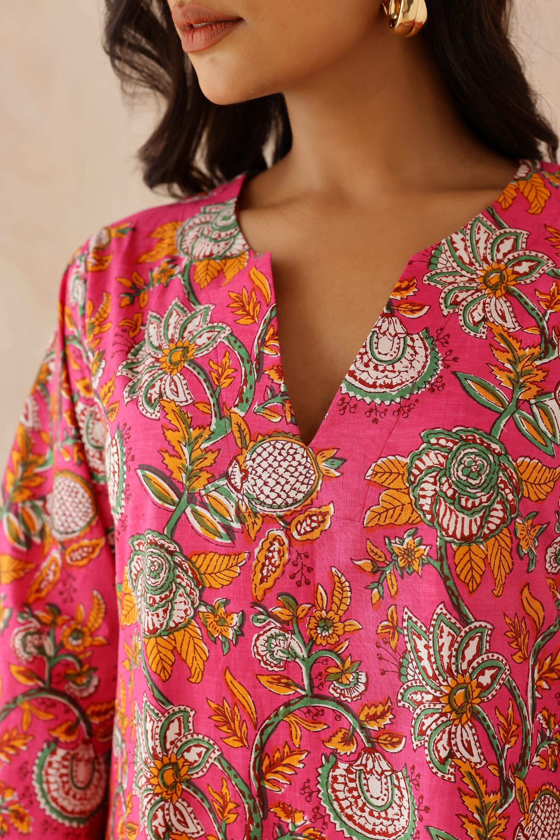 Woman wearing Pink Printed Cotton Kurta with Palazzo Set of 2 in light pink featuring all over prints, round to V neckline, full sleeves, and matching printed palazzo with elastic waist