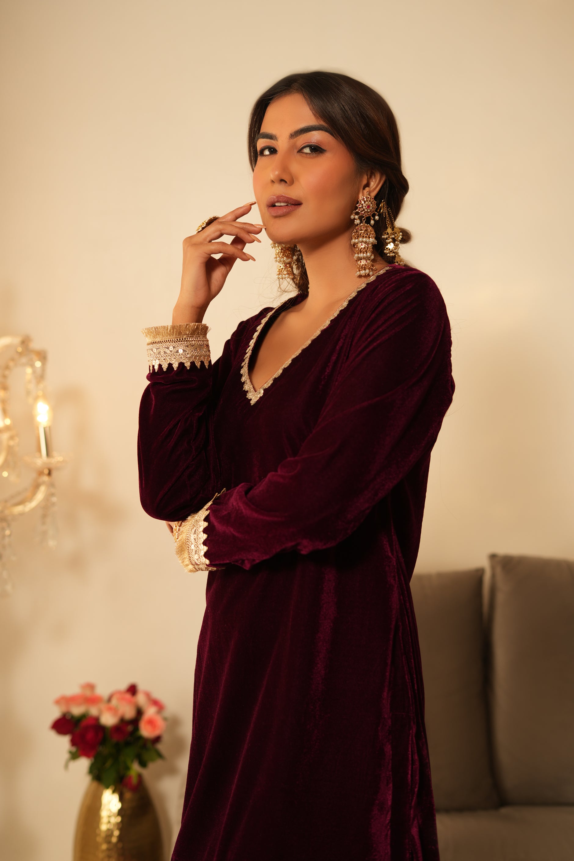 Woman wearing Wine Velvet Kurti with Sharara  featuring gota lace detailing on the sleeves, neckline and hem, V neckline, full sleeves, and matching wine velvet sharara 