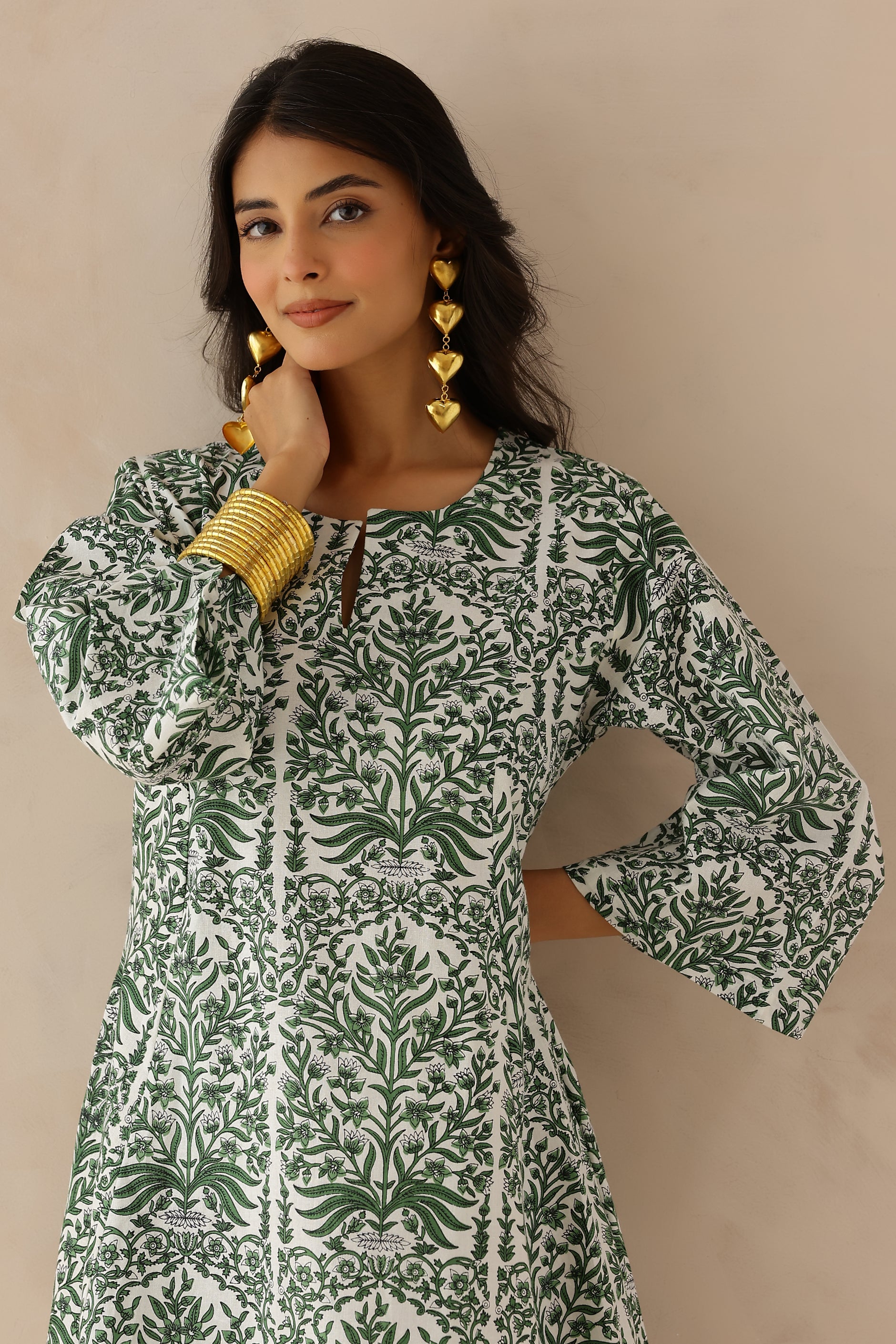 Woman wearing green and white printed cotton kurta with round V-cut neckline, 3/4 sleeves, and white cotton pants.