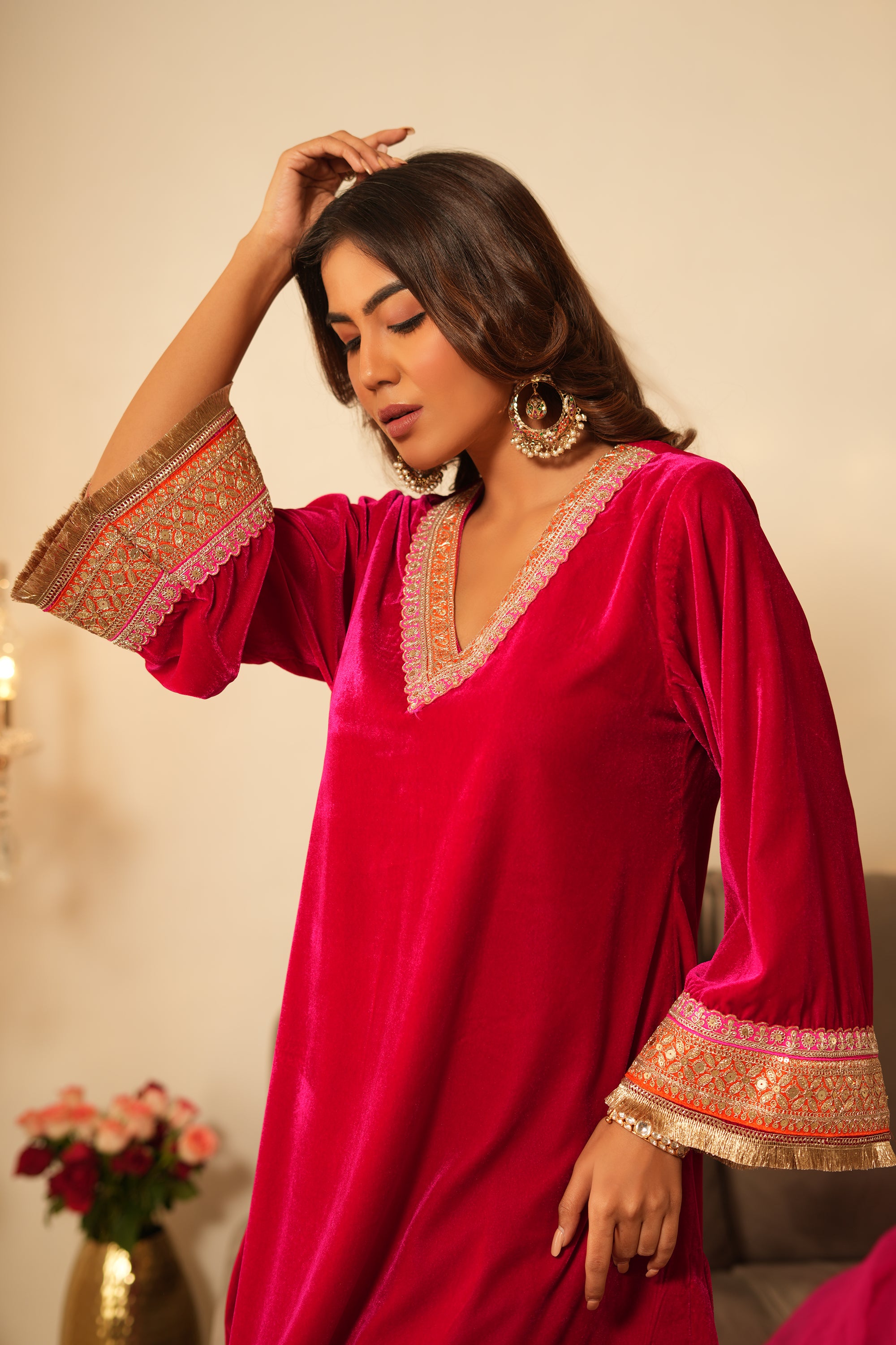 Woman in pink velvet gota lace kurta set with V-neckline, 3/4 sleeves, matching salwar, and organza dupatta.