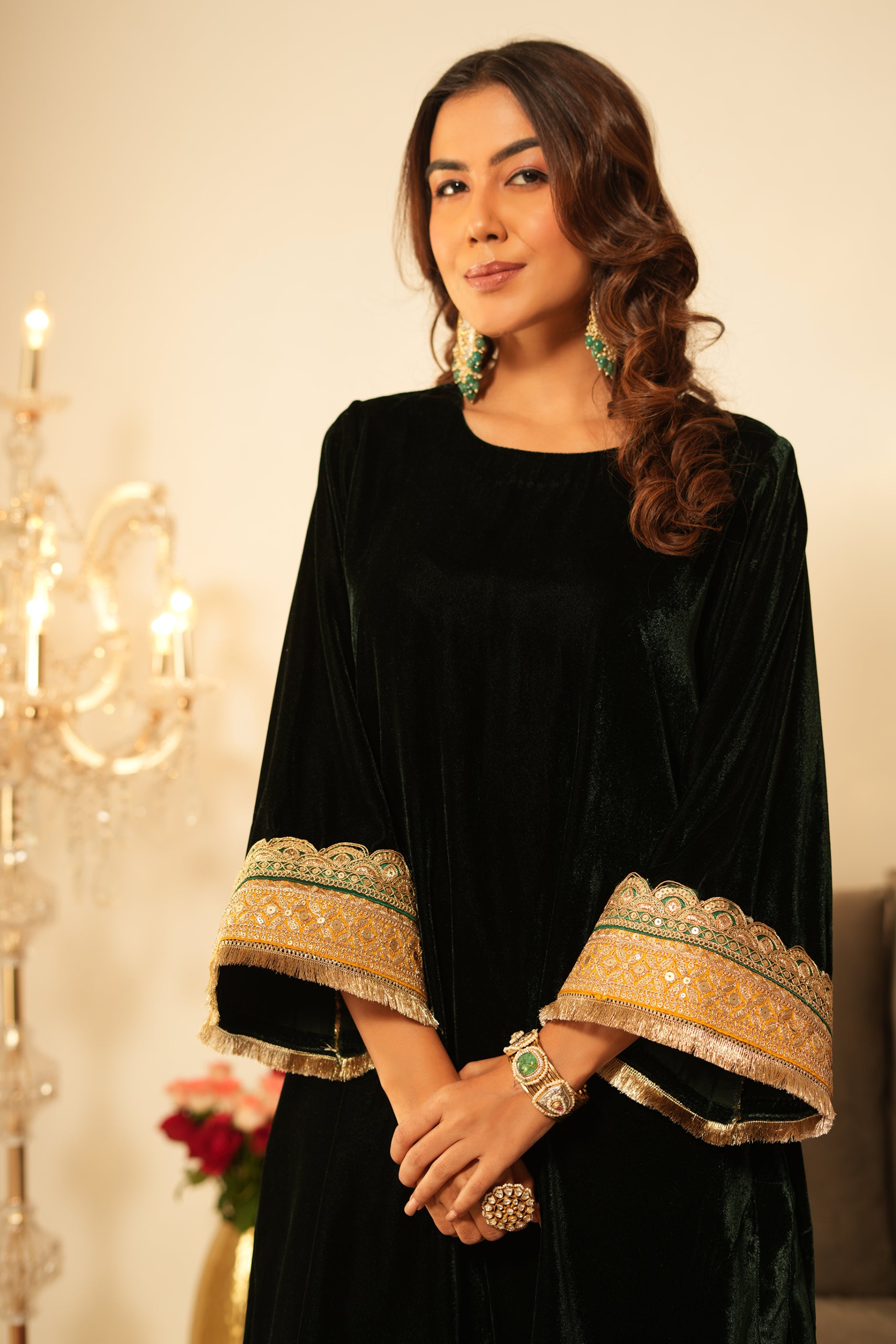 Woman wearing Green Velvet Kurta Set with Mustard Organza Dupatta featuring gota lace detailing, boat neckline, 3/4th sleeves, and matching green velvet pants with elastic waist and lace hem