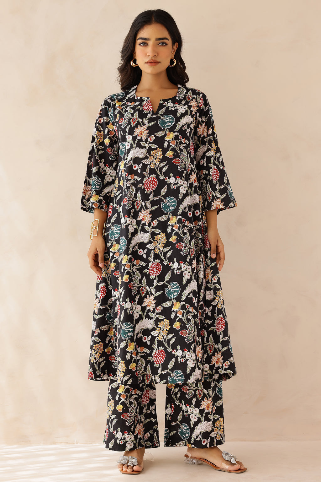 Woman wearing Multicolor Printed Cotton Kurta with Palazzo Set of 2 featuring all over multicolor prints, round to V neckline, 3/4th sleeves, and matching printed palazzo with elastic waist