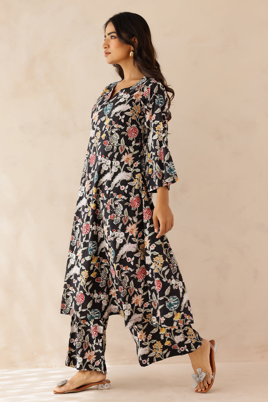 Woman wearing Multicolor Printed Cotton Kurta with Palazzo Set of 2 featuring all over multicolor prints, round to V neckline, 3/4th sleeves, and matching printed palazzo with elastic waist