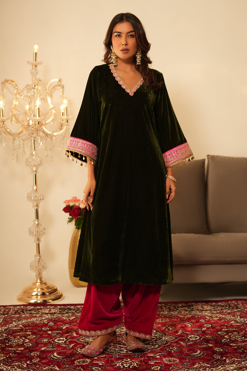 Woman wearing Mehendi Green Velvet Kurta with Pink Salwar Set of 2 featuring gota lace detailing, V neckline, 3/4th sleeves, and matching pink velvet salwar with elastic waist and lace hem