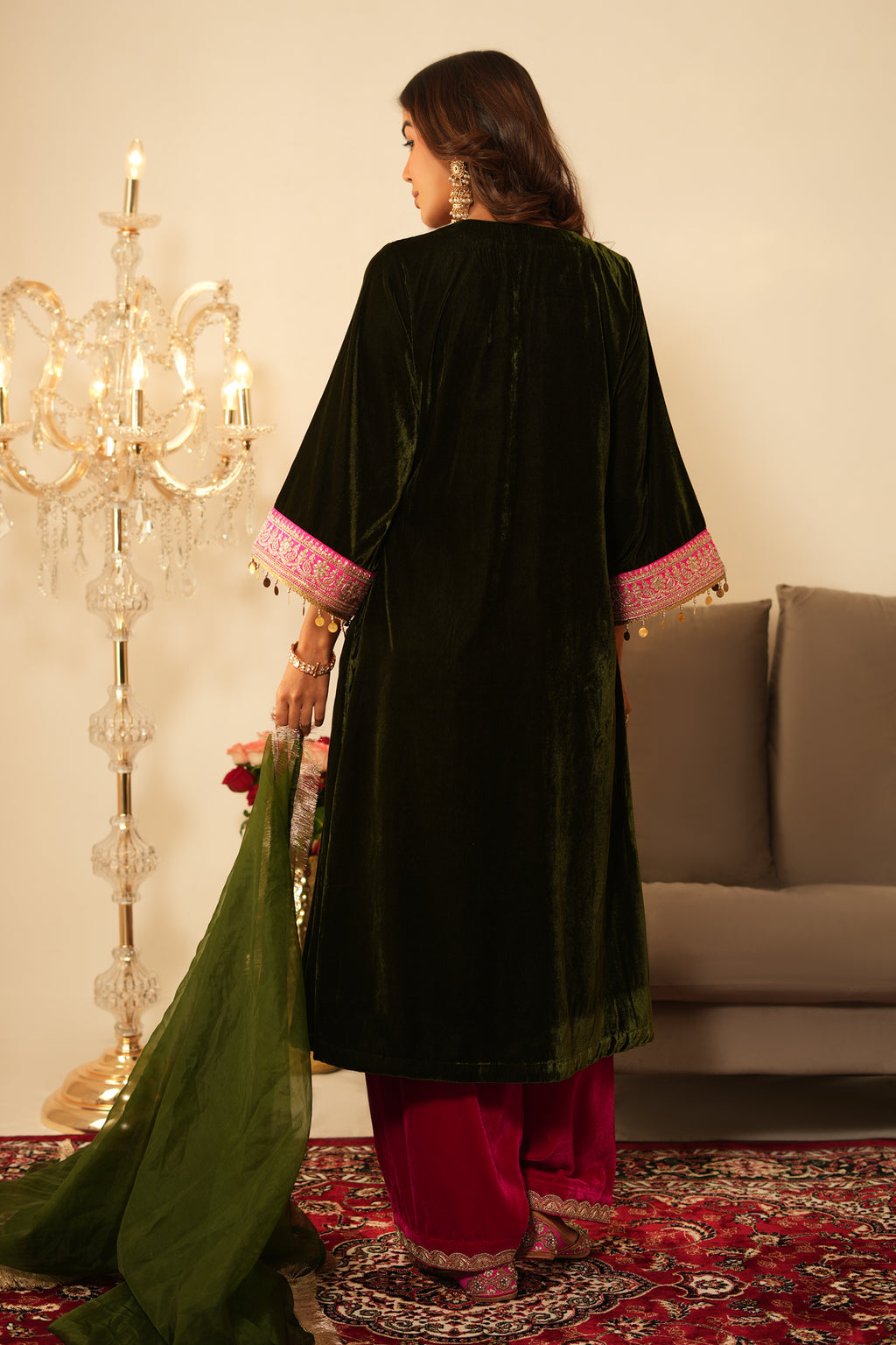 Woman wearing Mehendi Green Velvet Kurta with Pink Salwar Set of 2 featuring gota lace detailing, V neckline, 3/4th sleeves, and matching pink velvet salwar with elastic waist and lace hem