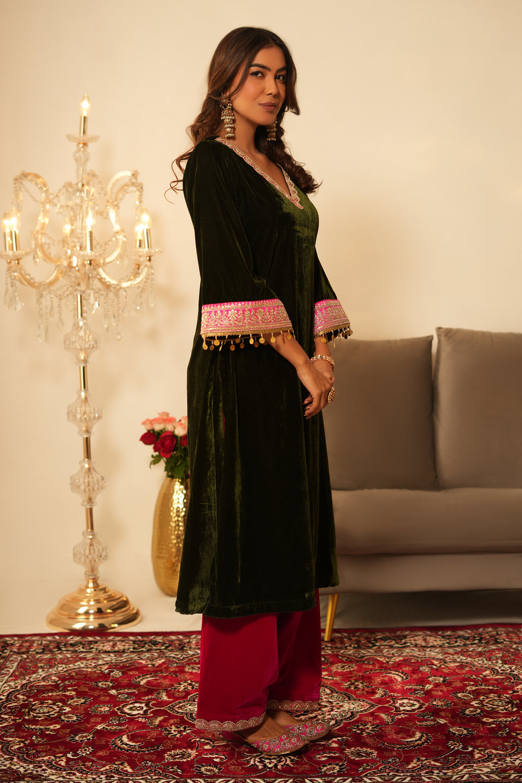 Woman wearing Mehendi Green Velvet Kurta with Pink Salwar Set of 2 featuring gota lace detailing, V neckline, 3/4th sleeves, and matching pink velvet salwar with elastic waist and lace hem