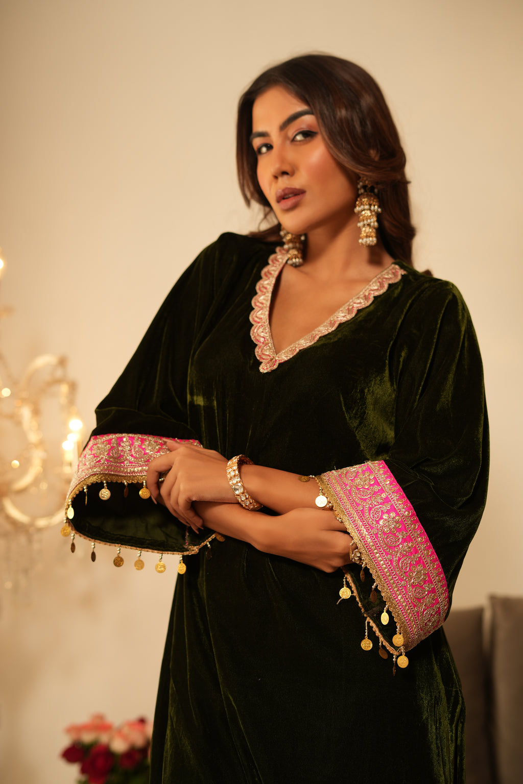 Woman wearing Mehendi Green Velvet Kurta with Pink Salwar Set of 2 featuring gota lace detailing, V neckline, 3/4th sleeves, and matching pink velvet salwar with elastic waist and lace hem