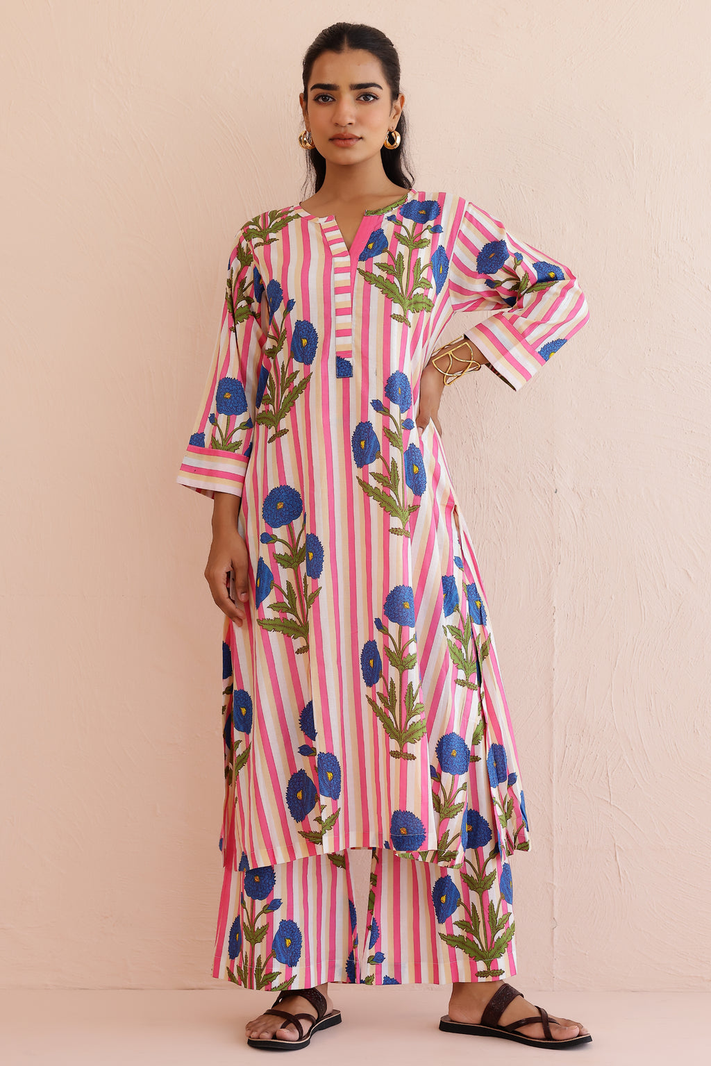 Woman wearing a pink blue printed cotton kurta with round V-neckline, 3/4th sleeves, and matching printed palazzo pants, styled in a soft, comfortable everyday ethnic look.