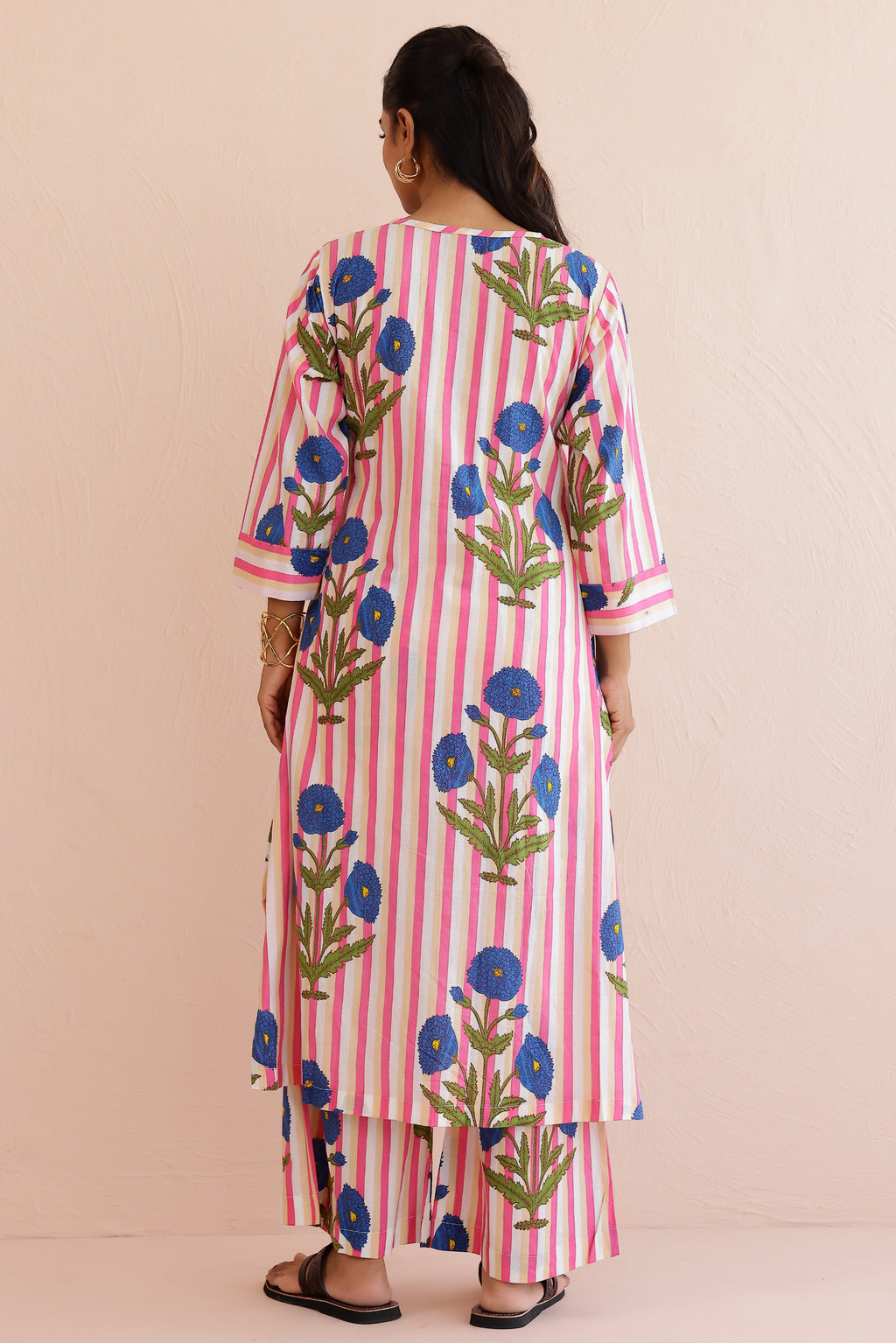 Woman wearing a pink blue printed cotton kurta with round V-neckline, 3/4th sleeves, and matching printed palazzo pants, styled in a soft, comfortable everyday ethnic look.