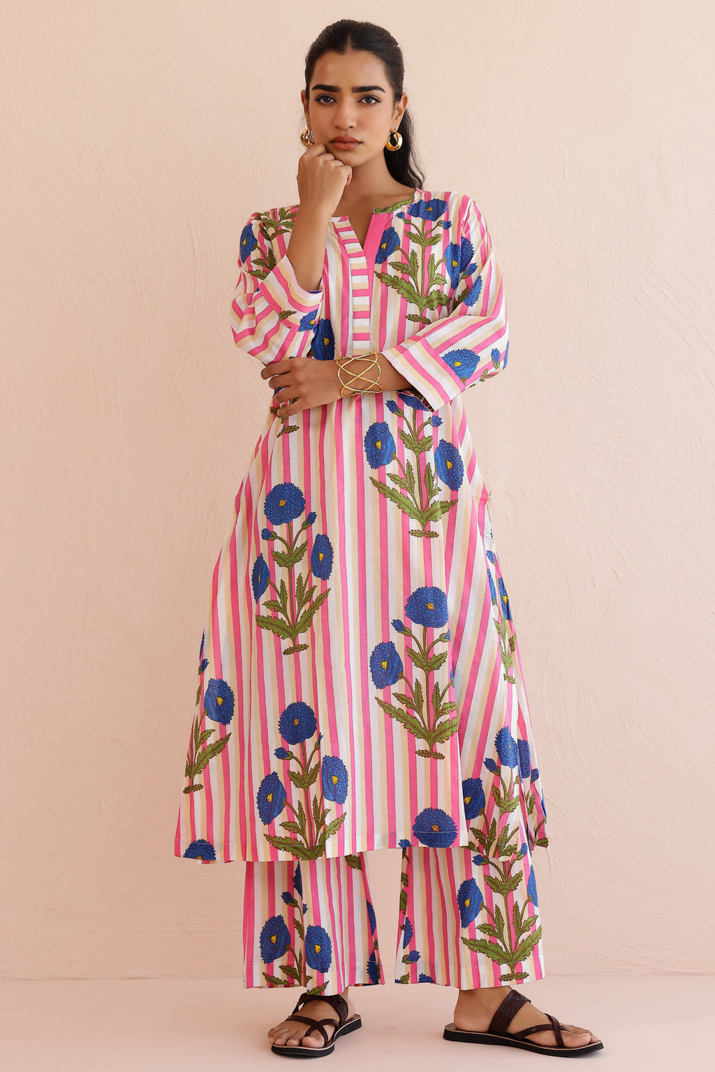 Woman wearing a pink blue printed cotton kurta with round V-neckline, 3/4th sleeves, and matching printed palazzo pants, styled in a soft, comfortable everyday ethnic look.