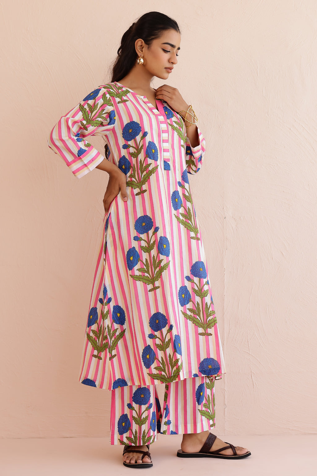 Woman wearing a pink blue printed cotton kurta with round V-neckline, 3/4th sleeves, and matching printed palazzo pants, styled in a soft, comfortable everyday ethnic look.