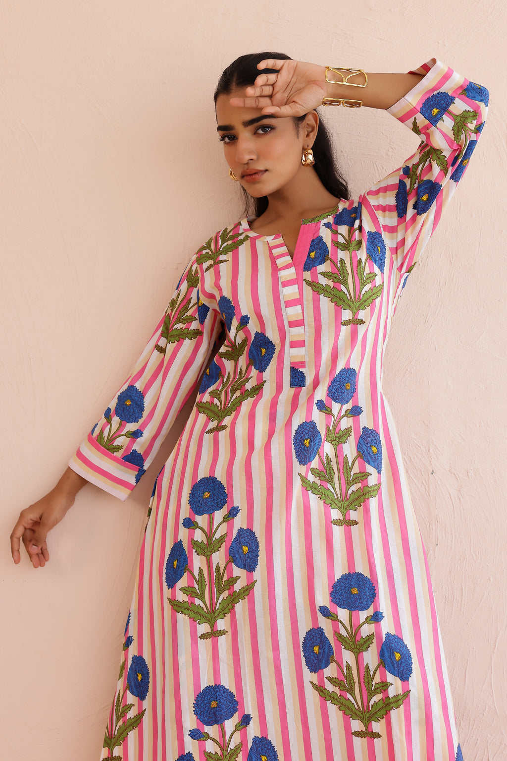 Woman wearing a pink blue printed cotton kurta with round V-neckline, 3/4th sleeves, and matching printed palazzo pants, styled in a soft, comfortable everyday ethnic look.