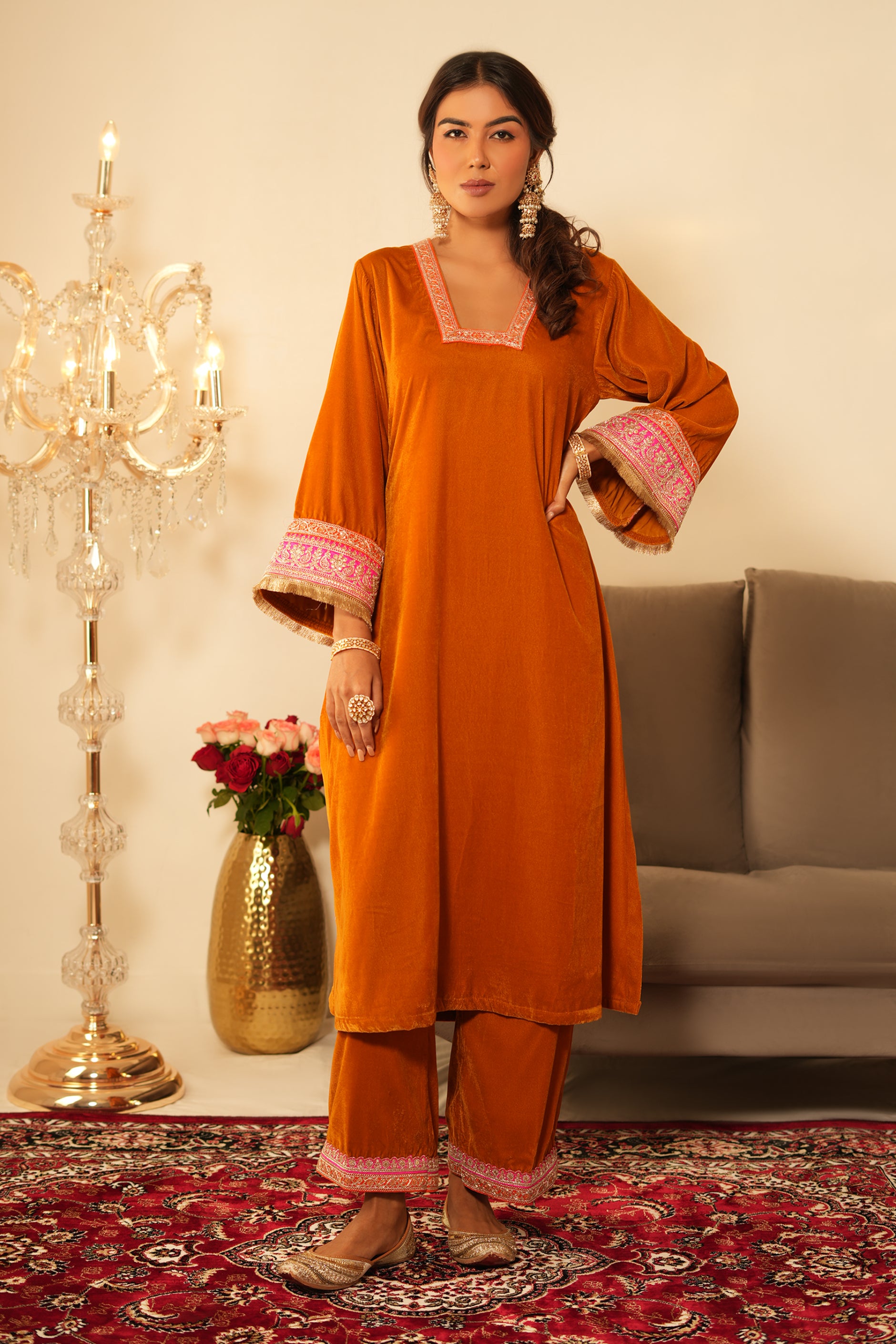 Woman wearing Mustard Velvet Kurta with Pants Set of 2 featuring gota lace detailing on neckline, sleeves and pant hem, blunt V neckline, full sleeves, and matching mustard pants 