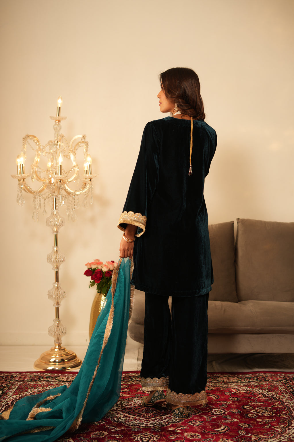 Woman in a  Blue Gota Lace Velvet Co-ord set which features Gota lace work detailing, a V-neckline, and Full sleeves. 