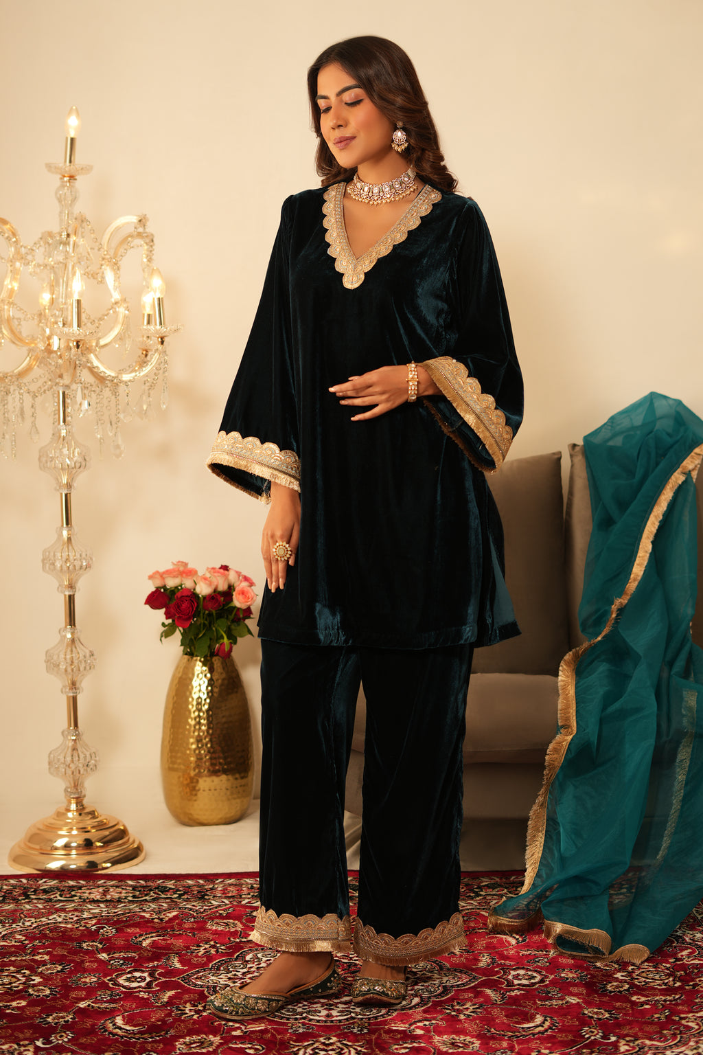 Woman in a  Blue Gota Lace Velvet Co-ord set which features Gota lace work detailing, a V-neckline, and Full sleeves. 